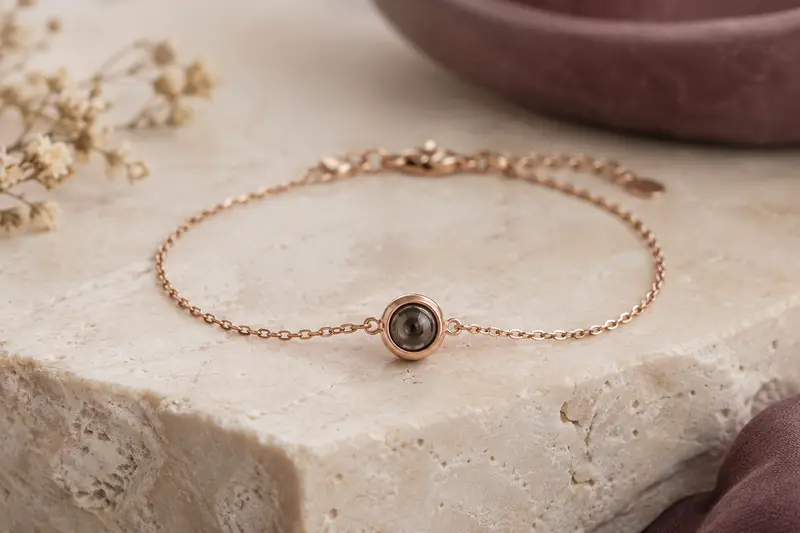 Bracelet fin avec petit élément optique rond posé sur une surface en pierre ivoire